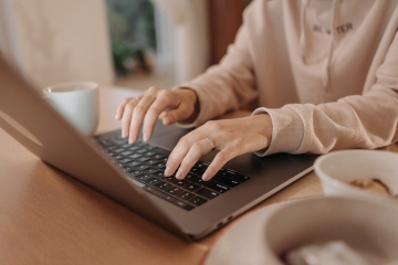 Frau tippt auf einem Laptop