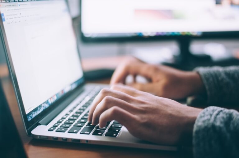 Person schreibt SEO-optimierte Texte am Laptop fuer Unternehmenswebsite