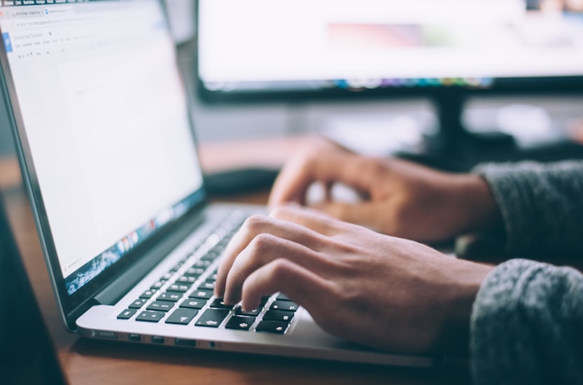 Person schreibt SEO-optimierte Texte am Laptop fuer Unternehmenswebsite